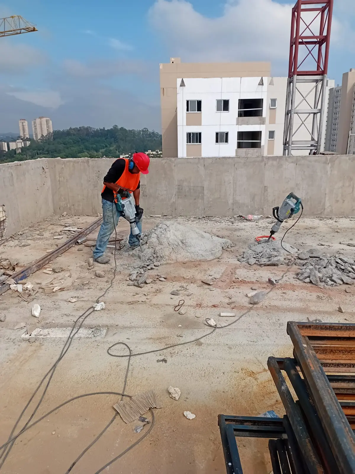 Quebra de concreto com martelete rompedor em área de obra