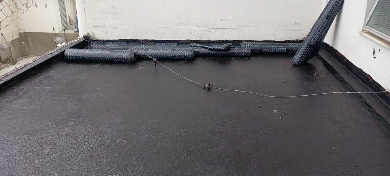 Superfície preparada com rolos de manta asfáltica posicionados