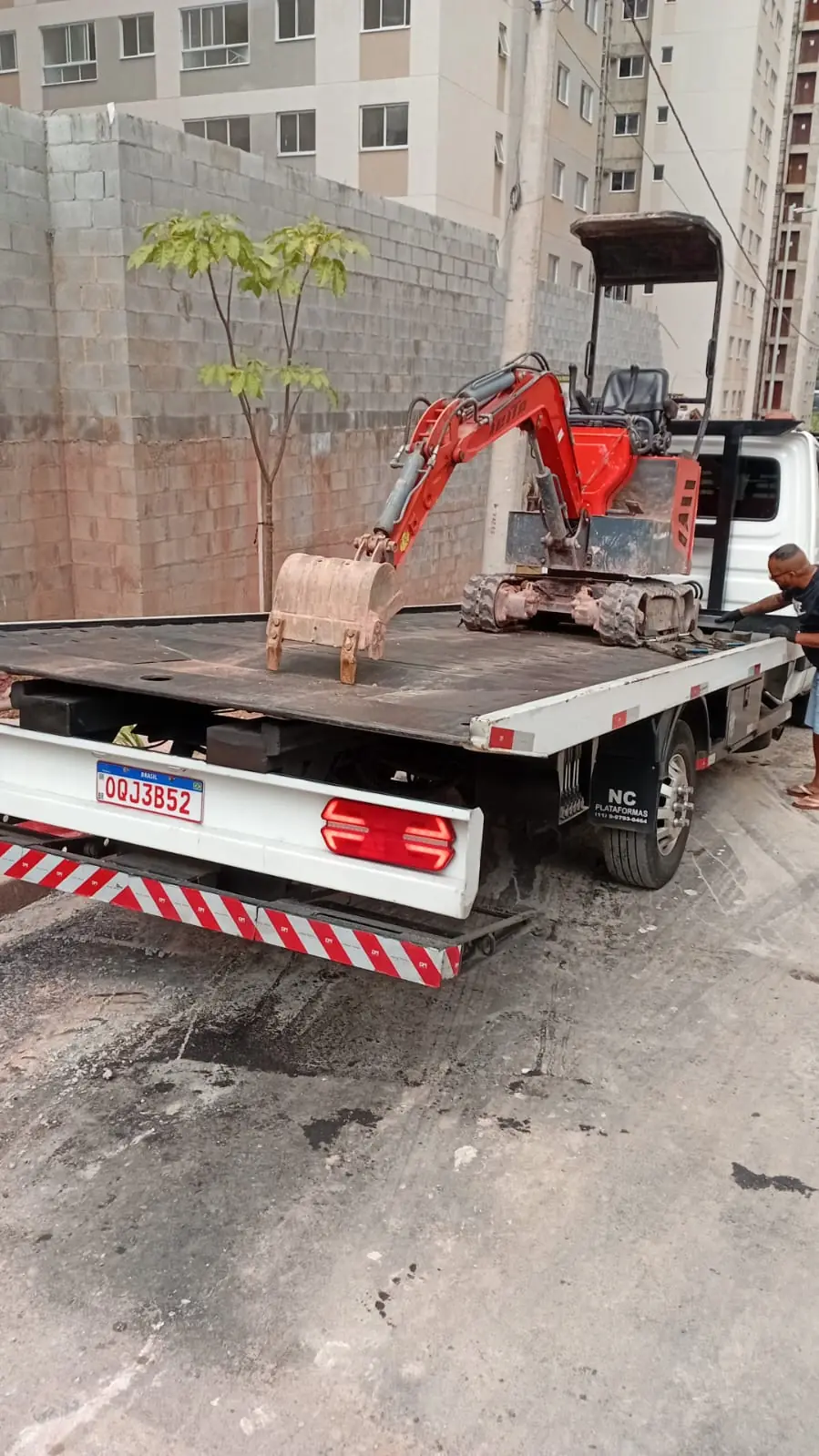 Miniescavadeira transportada sobre caminhão plataforma