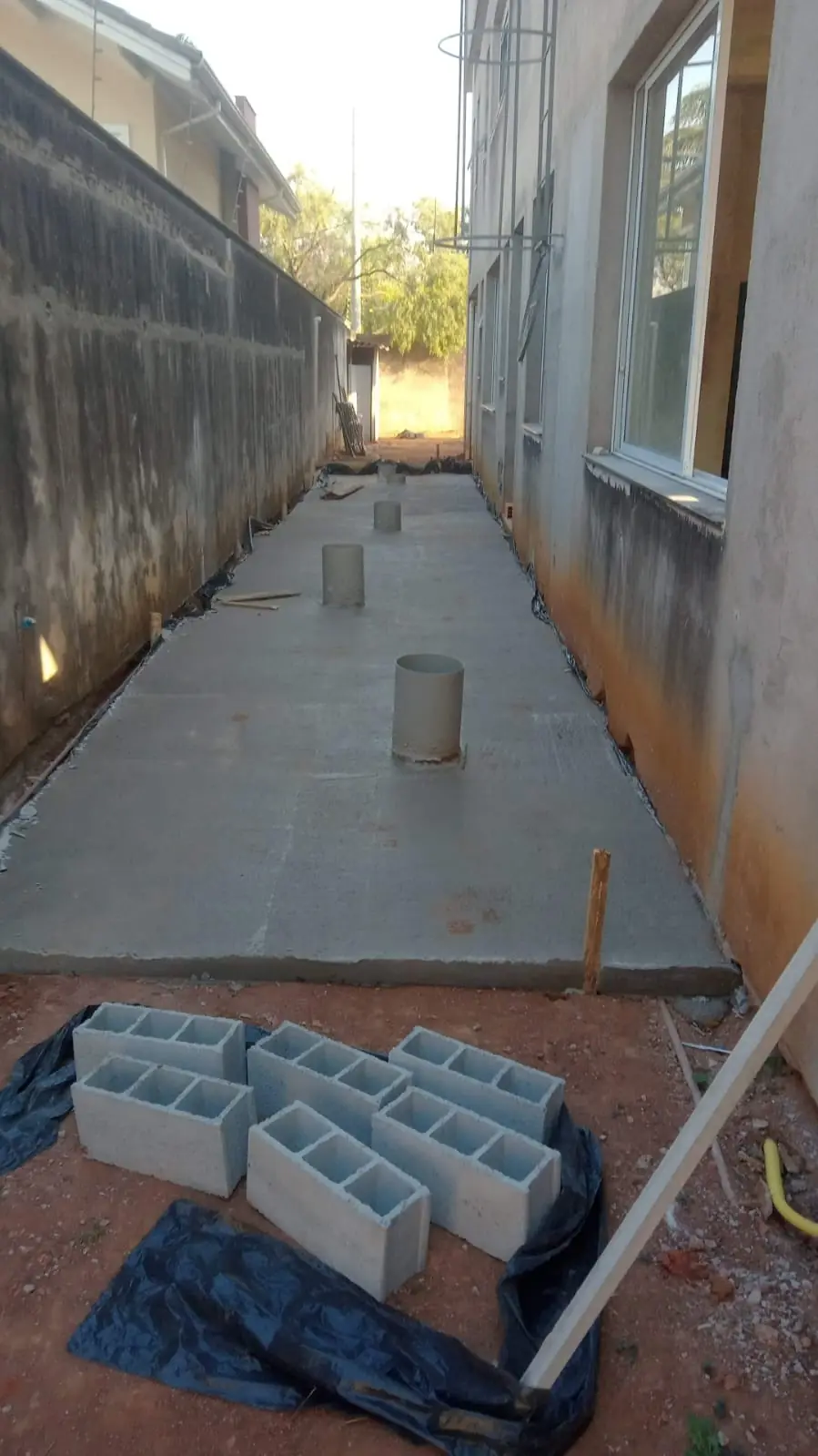 Corredor externo com contrapiso executado e blocos de concreto
