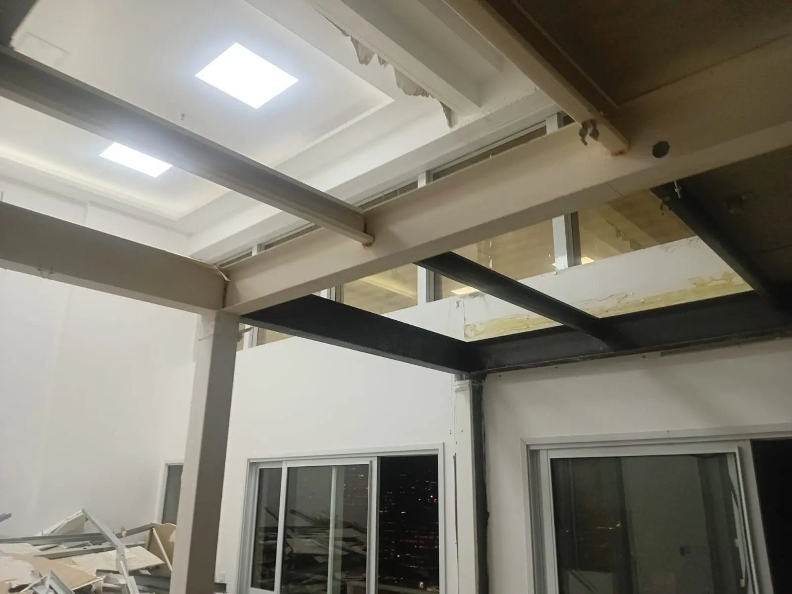 Ambiente interno com vigas metálicas e iluminação de forro
