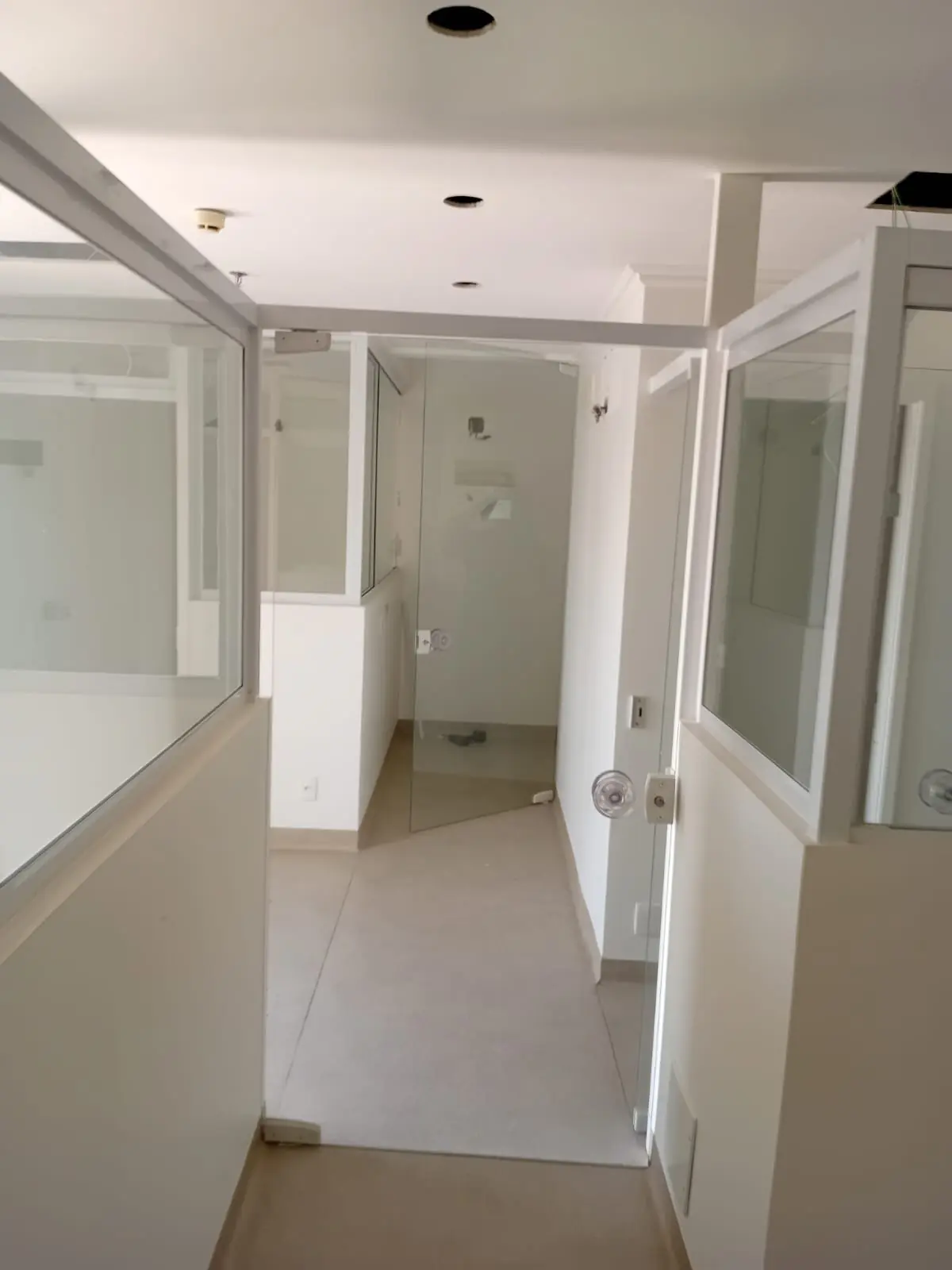 Ambiente interno com divisórias de vidro e piso cerâmico