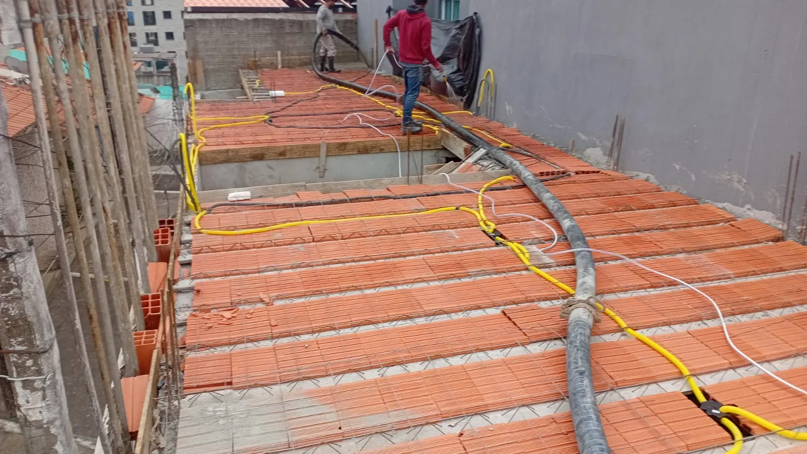 Laje com lajotas cerâmicas, eletrodutos e mangote posicionados para concretagem
